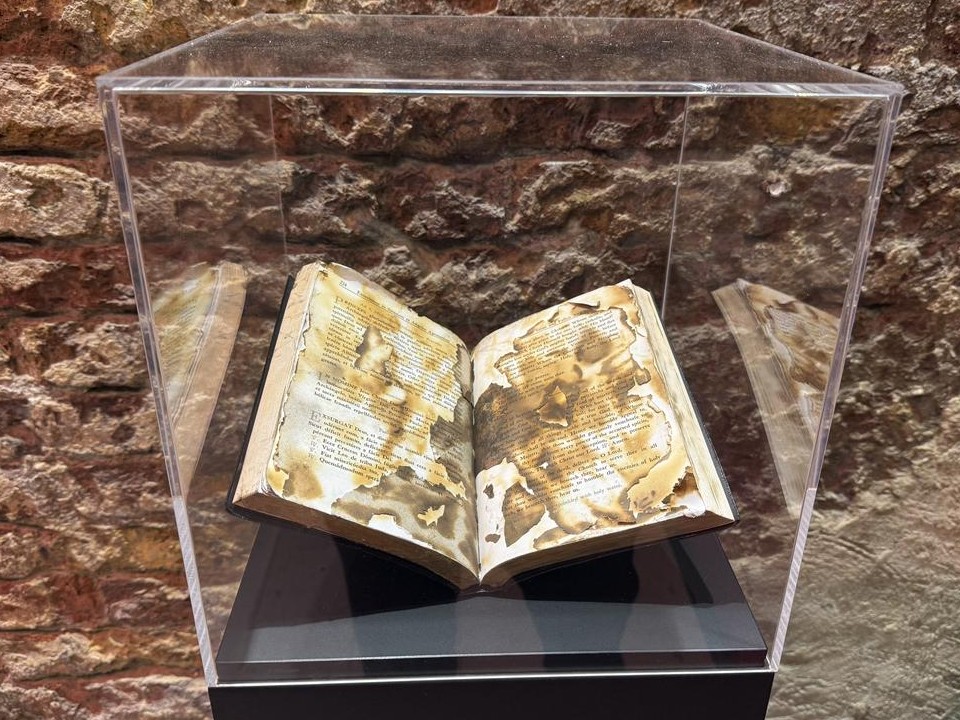 Burned open book displayed inside a clear case